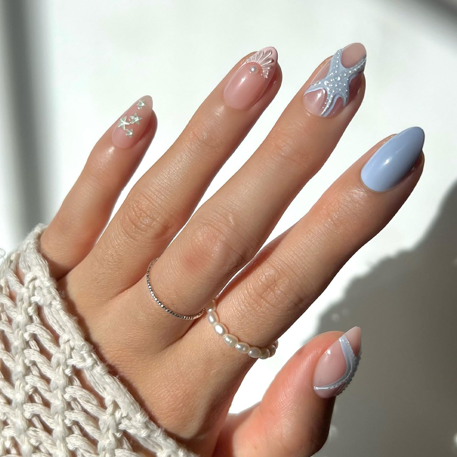 Glamnetic Starfish press-on nails close-up showing 3D starfish, shell accents, and periwinkle blue almond shape